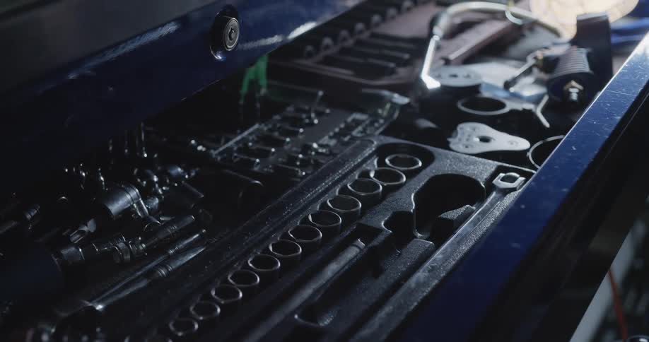 Hands reaching for a socket and wrench then taking apart and putting away in a toolbox