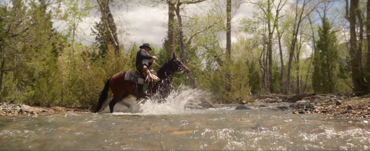 Men struggle to get their horses to cross a river and get back on land