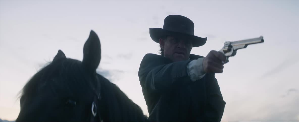A man on a horse pulls a gun and points it