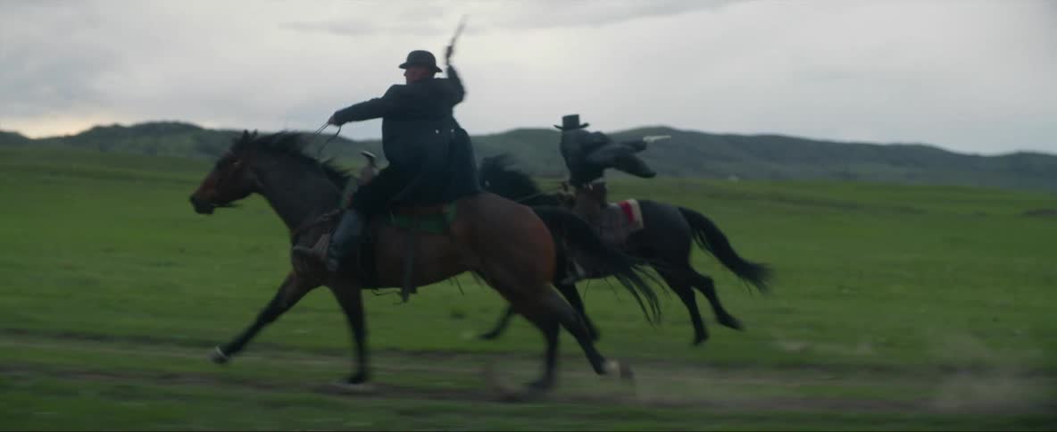A couple of wild west cowboys riding horses shoot back while escaping