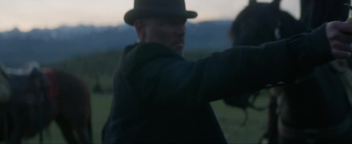 A man discounts his horse and pulls and points a gun