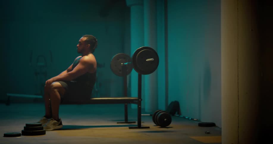 A man attaches weights to a barbell before beginning to lift weights