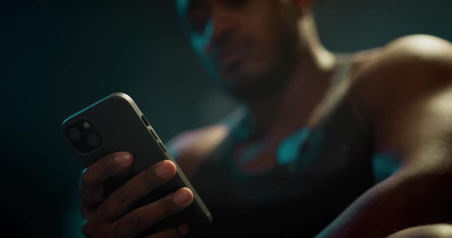 A man is sitting down holding his cell phone