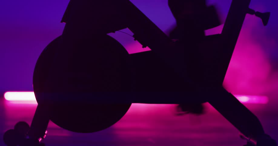 A persons legs using a stationery bike quickly