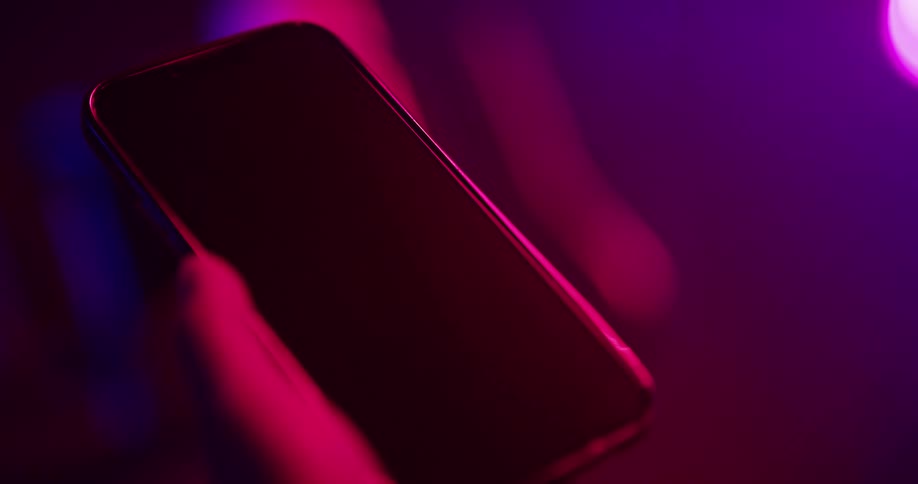 A person is holding their cell phone indoors