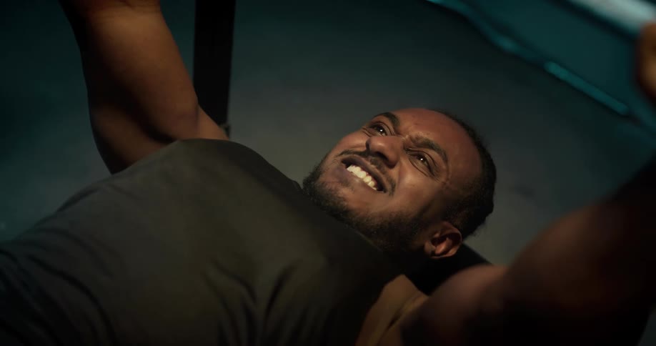 A man is lifting weights at a gym indoors