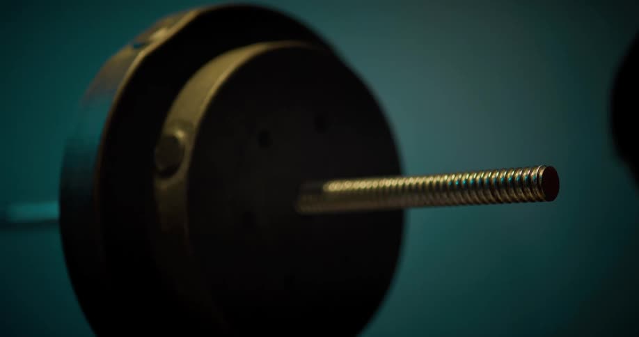 Two hands put weights on a barbell
