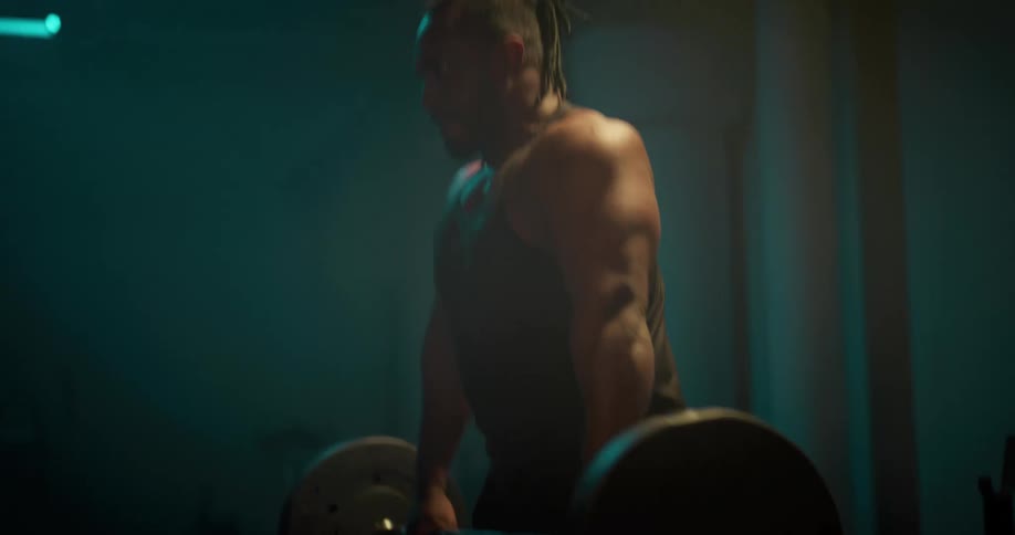 A man is standing in a room lifting weights