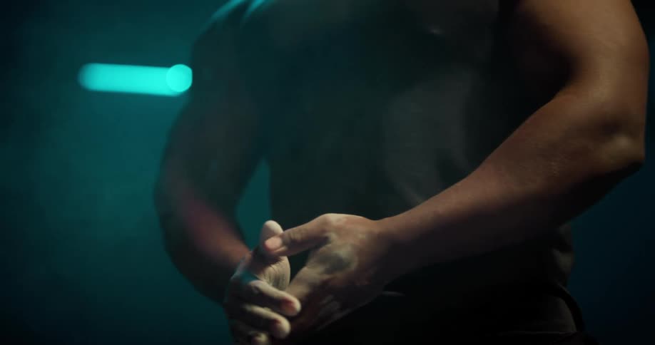 Strong muscular man claps his hands spreading talcum powder