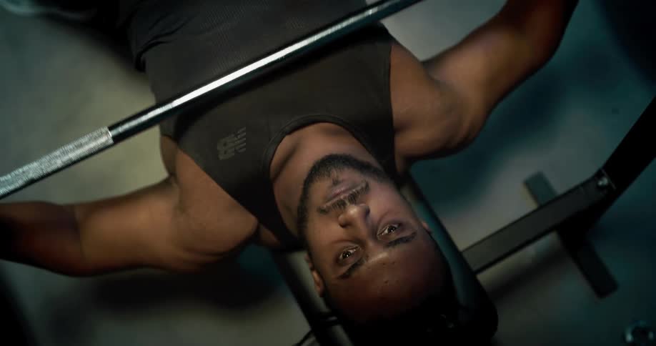 Strong muscular young man lift weights at the gym