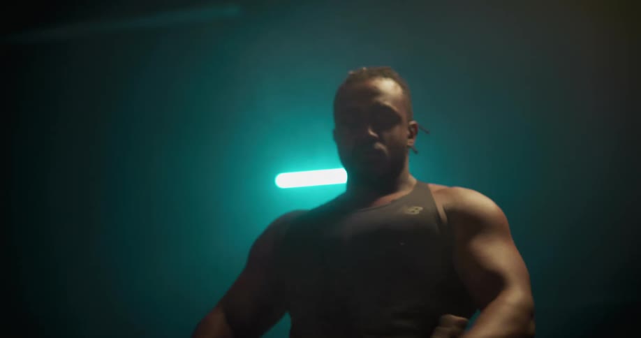 A muscular man rubs chalk on his hand and claps before beginning to take deep breaths