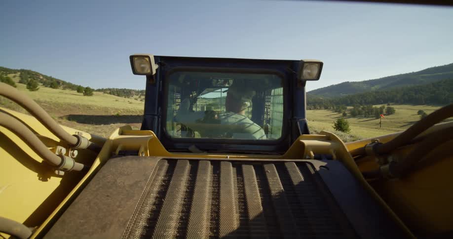 A farmer gets into his trailer in a field