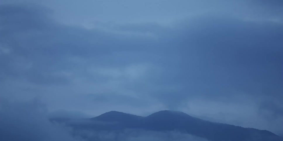 Thick fog covers the peaks of a mountain range