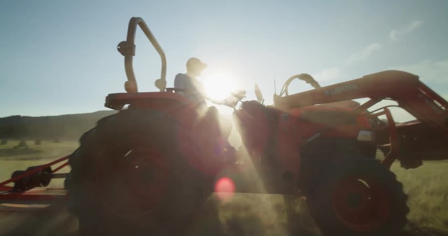 A man is running the tractor on the farm
