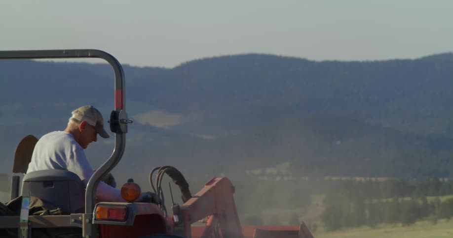 A farmer drives a tractor onto the field