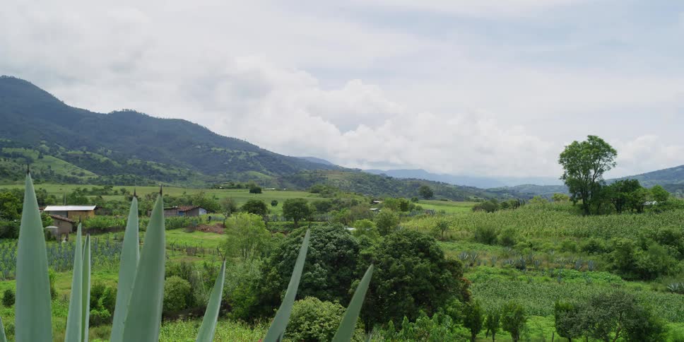 Houses sit in valley stretching to misty mountains on the horizon
