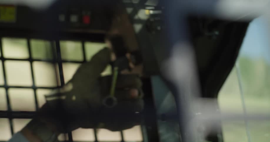 Man sitting in driver cage of heavy machinery turns key in ignition