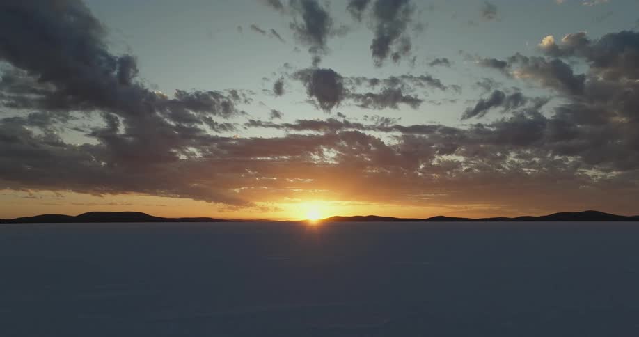 The sun is rising on the snow filled landscape