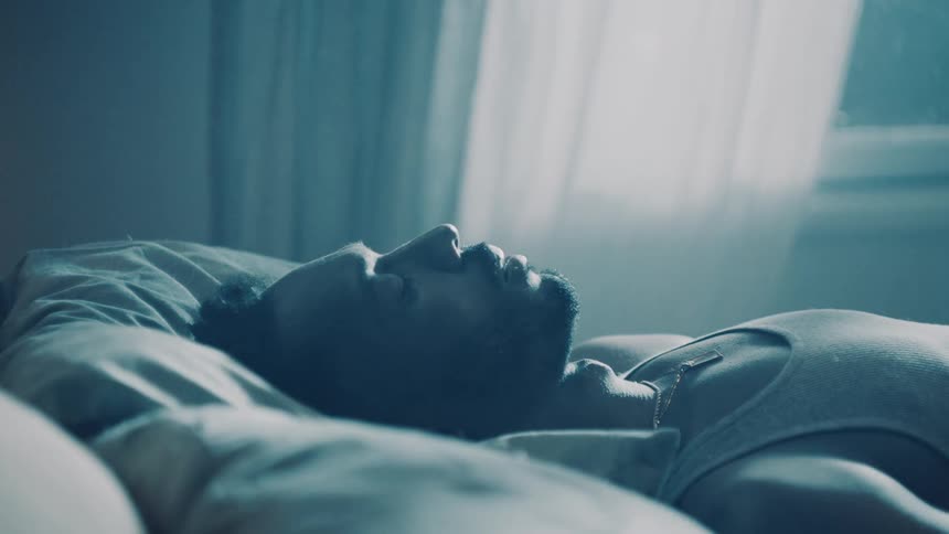 Young man deeply asleep in the bed at home