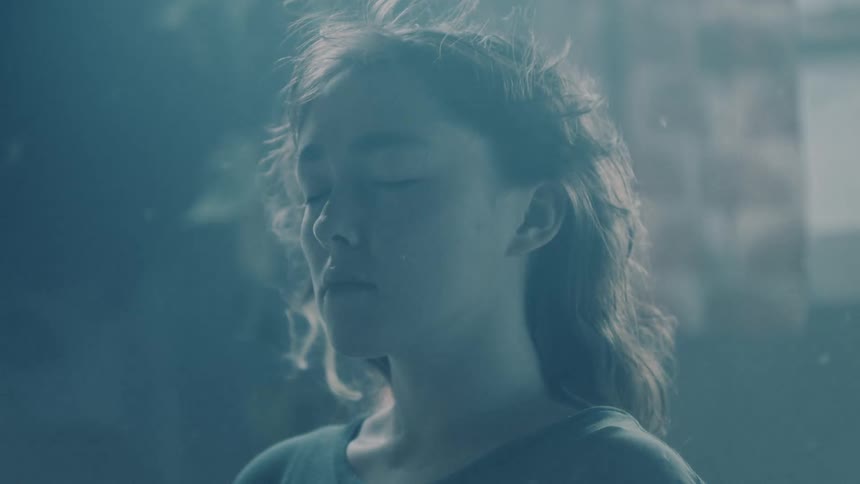 A woman slowly falls on the bed