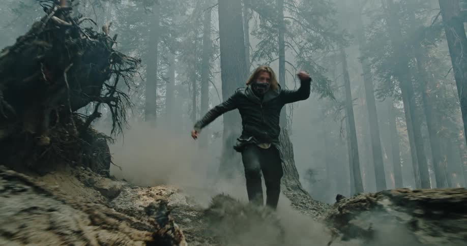 A man runs through the forest as the ground shakes