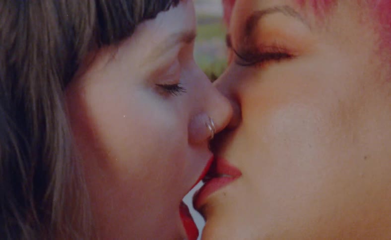 Two women are making out together outdoors