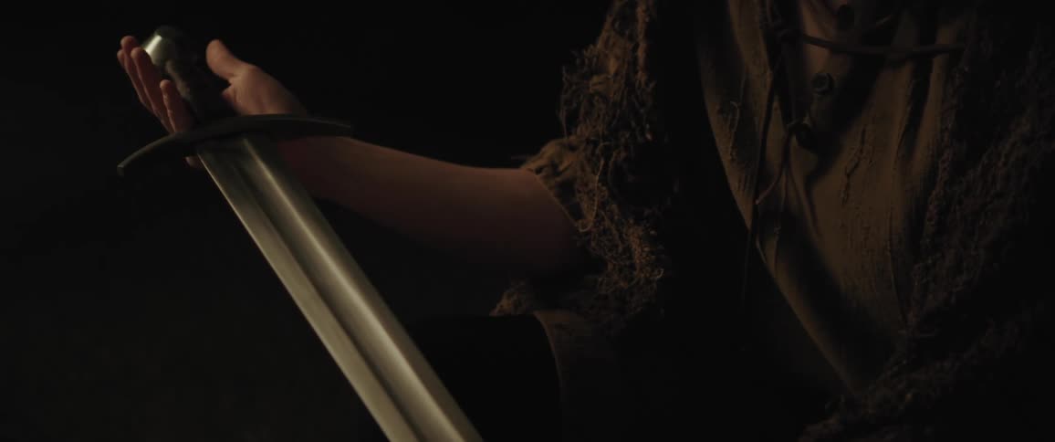 A young medieval man holding out a sword