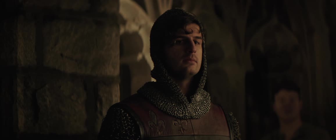 A medieval knight standing in a castle looking off