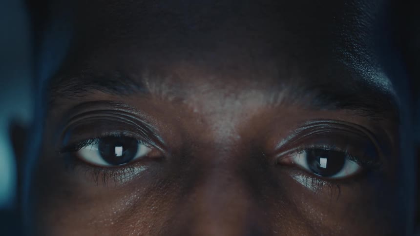 Time lapse close up of the eyes of a man looking at a phone screen at night