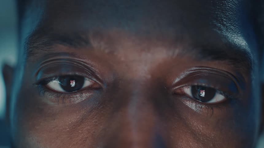 Close up time lapse of the eyes of a man looking at the screen of a phone