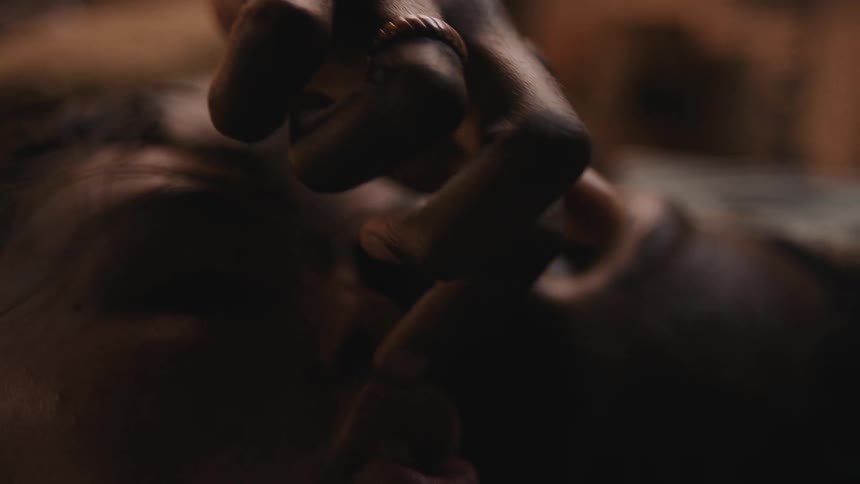 Couple leans with their heads together as man traces womans lips