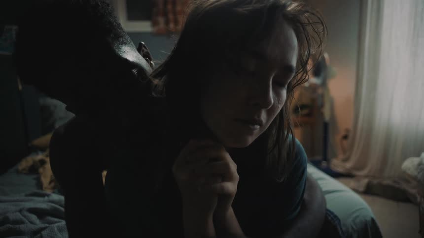 Man hugs woman to comfort her while sitting on the bed