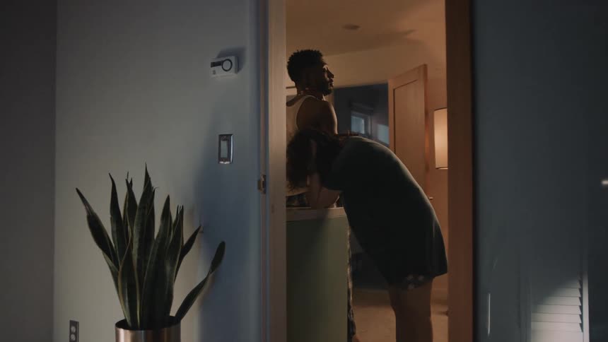 Young couple stand together in a room at home