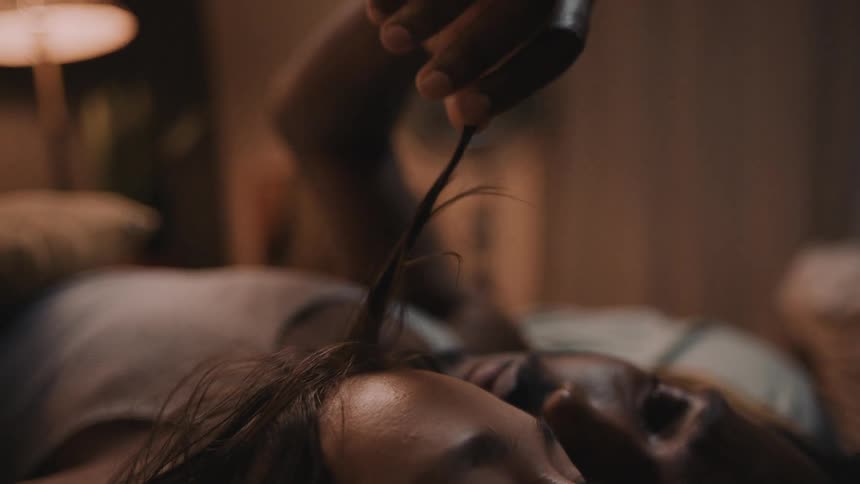 Couple lie next to each as man strokes womans hair