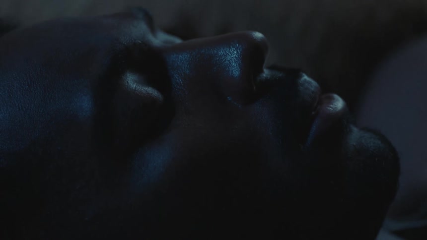 Man lying on bed asleep turns his head