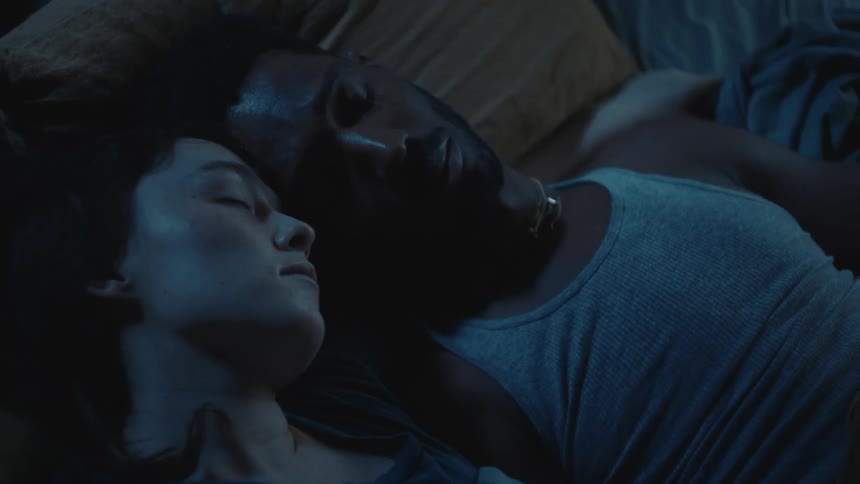 Couple sleeping close together are disturbed and wake to look