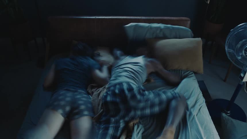 Time lapse of a couple tossing and turning while sleeping at night