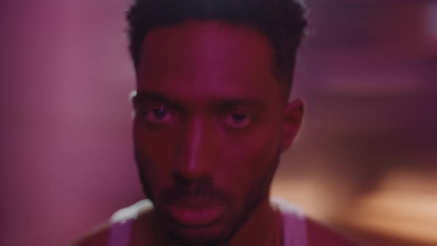 Man opens his eyes briefly to stare as background rotates behind him