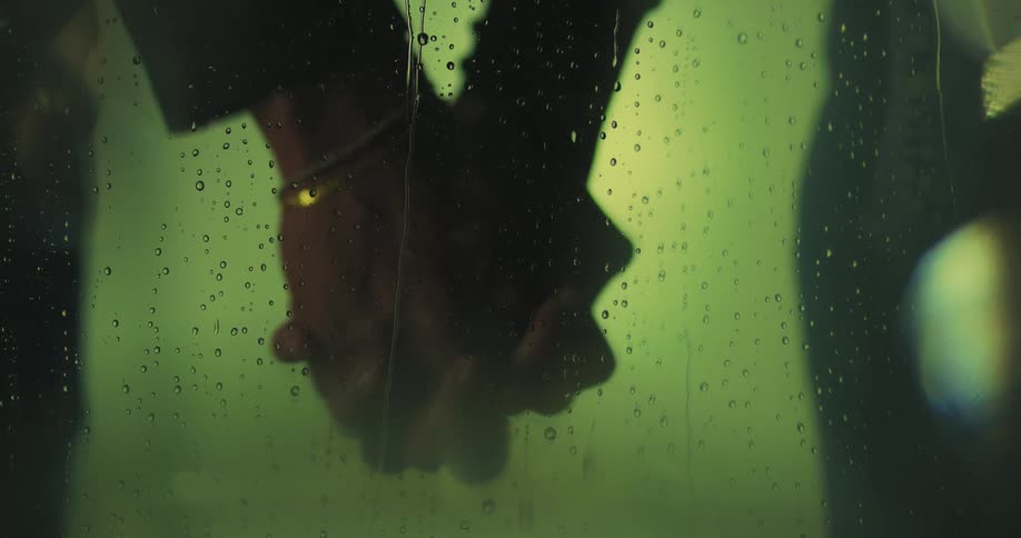 Couple reaches out to hold hands as water drops flow down glass
