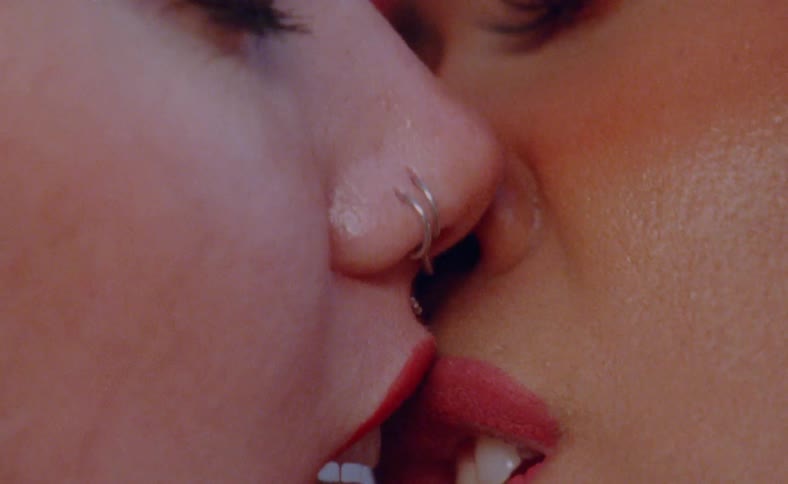 Two women passionately kiss each other on the lips multiple times