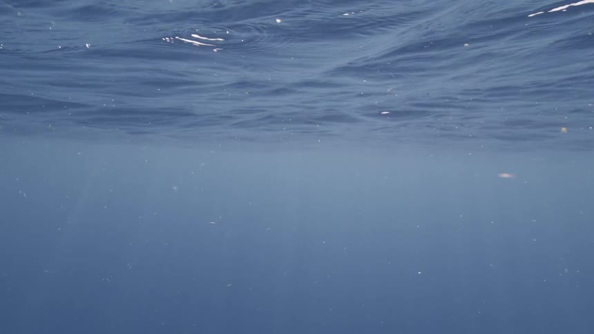Underwater view of water rippling and waving as the sun shines on the surface