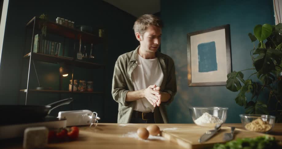 A man is in his kitchen and ready to cook a meal