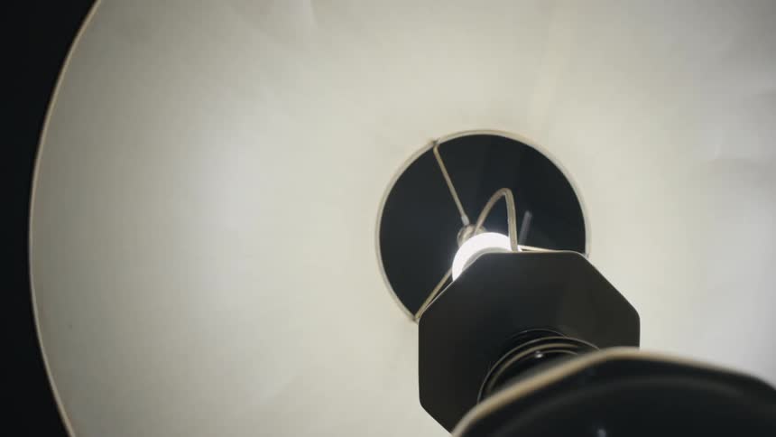 A person shuts off their lamp