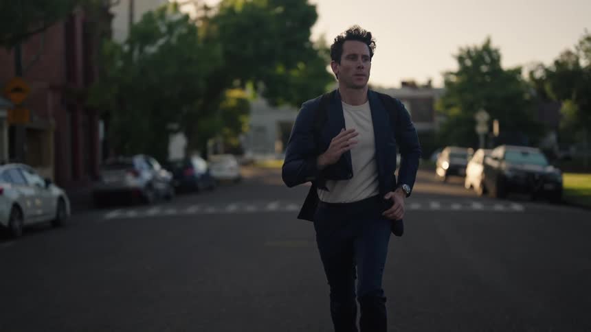 A man runs down the middle of the street in a suit
