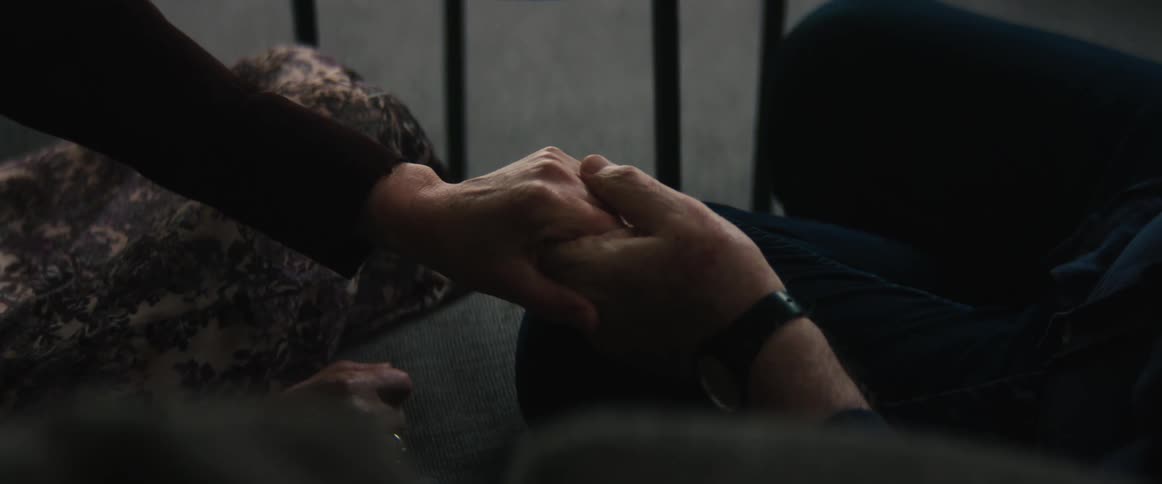 A man holds a womans hand and hands her an envelope