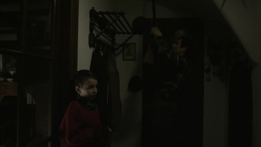 Father hands rifle to young son and checks second rifle before leading boy along