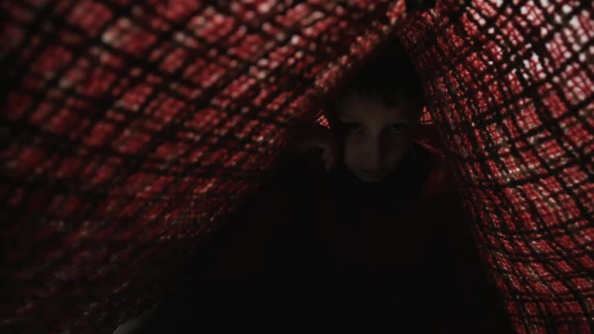 A child is under the blanket tent