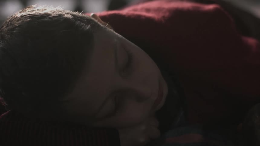 Close up of a young woman resting on a room looking at the camera
