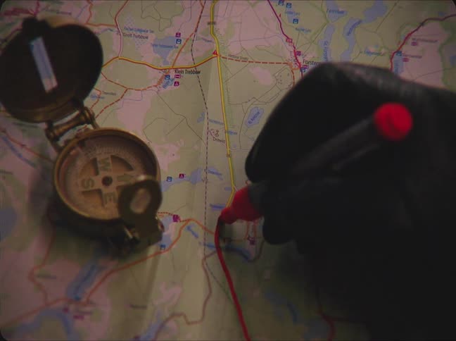 A person is drawing on a map with a marker