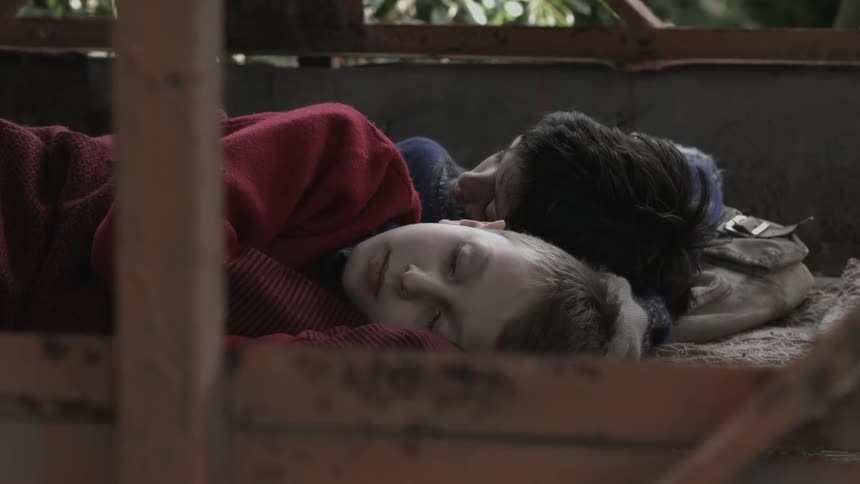 Two boys are taking a nap on a porch